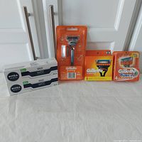 Full view of the lot showing all items: Gillette Fusion 5 razor handle, 8 replacement cartridges, 4 Fusion Power cartridges, and 2 boxes of Nivea Men shaving cream.
