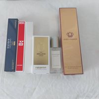 Full view of all six fragrance boxes and bottles visible on white cloth background showing varying sizes and packaging.