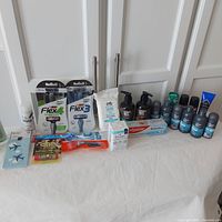 Full lot image including all personal care products, razors, toothbrush, toothpaste, and luggage tag displayed on a white table