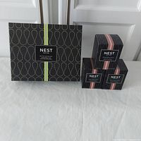 Overview of all candles including boxed petite votive set and three boxed rose noir & oud candles