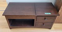 Dark wood coffee table with a partial lift top closed, two drawers on the right, and an open shelf below the lift section.