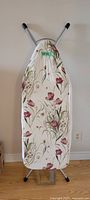 Front view of ironing board showing floral cover and frame.
