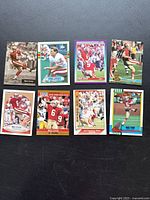 Full set of eight Mike Cofer football trading cards laid out on dark surface, showing various poses and designs from 1990.