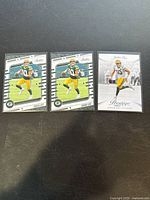 Five Jordan Love trading cards displayed on a dark surface; four are 2020 Panini Absolute cards, one is a 2020 Panini Prestige card. Cards feature Jordan Love in Green Bay Packers uniform in action poses.