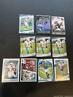 Top view of all 10 Tua Tagovailoa trading cards laid out on a black surface showing front sides