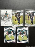 Five Jalen Hurts 2021 Philadelphia Eagles trading cards laid out on a black surface.