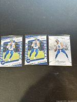 Three Matthew Stafford football cards on black background in plastic sleeves, two Panini Absolute Football and one Panini Prestige