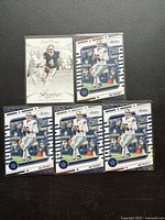 Overview photo showing six Dak Prescott football trading cards from Panini including five Absolute Football cards and one Prestige card, all sleeved.