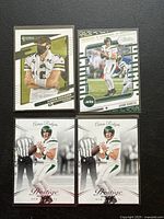 Four Aaron Rodgers football cards displayed on a black surface, showing front designs and player in Jets uniform.