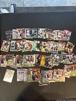 Wide view showing multiple football trading cards displayed on a black surface including the Erik Kramer card.