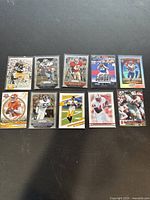 Photo of 10 football trading cards featuring Lawrence Taylor, Tommy DeVito, Adrian Peterson, Ben Roethlisberger, LeVeon Bell, Ronnie Lott, DJ Uiagalelei, Tony Dorsett, and others.