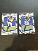 Photo of two Jonathan Taylor Panini Absolute Football cards side by side, showing front design, Colts team colors, card number 46.