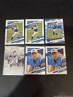 Photo showing six different Justin Herbert Panini football trading cards in mint condition, depicting player in action and portrait shots with Los Angeles Chargers branding.