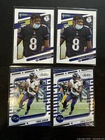 Four Lamar Jackson football trading cards, two with standing photo and two with action running photo, front side shown clearly.