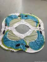 full view of deflated four-person pool float showing mesh seats, handles, cup holders