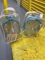 Two snorkel masks in clear carrying cases standing upright
