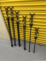 Six FieryDeer shooting sticks standing against yellow door