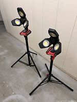 Both tripod work lights folded open standing on floor