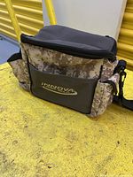 Front view of Innova camo shoulder bag with logo visible