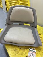 Front view of molded plastic folding boat seat with cushions visible