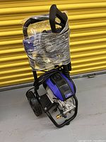 Full view of pressure washer on wheeled cart, wrapped in plastic