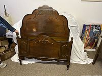 Front view of walnut French Provincial style antique single bed headboard and footboard together, showing carved details and polished finish.