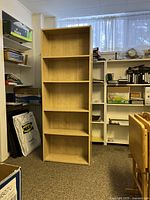 Full view of the 5-shelf bookshelf showing its height, width, and shelf spacing in a utility/storage room.