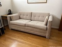 Front view of beige corduroy sofa with dual seat and back cushions
