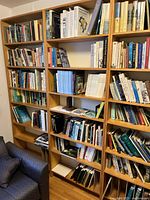 Full view of a handmade 7-shelf pine veneer bookshelf filled with various books, showing scale and shelf spacing.