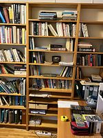 Bookshelf among other bookshelves, alone with books on shelves, showing overall height and width