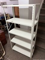 Front and side view of a white metal utility shelf with four adjustable shelves and cross braces for stability.