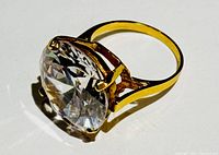 Three-quarter angle view showing overall appearance, band and faceted oval gemstone.