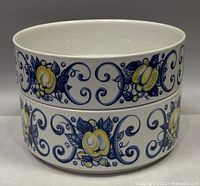 Stacked view of two Villeroy & Boch Cadiz serving bowls showing patterned exterior with blue scrolls and yellow fruit design.