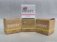 Four DKNY Eau de Parfum original boxes showing brand and volume details, arranged in a line.