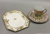 Full view of porcelain set showing octagonal cookie plate, teacup, and matching saucer