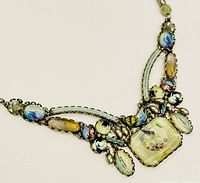 Close-up image of the multicolored beads and braided design of the necklace showing central square bead and surrounding beads.