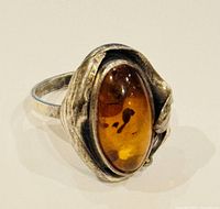 Front angled close-up showing amber cabochon and silver setting