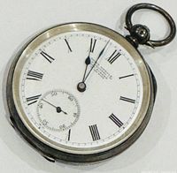 Front view of pocket watch showing white dial with black Roman numerals, subsidiary seconds dial, and blue hands.