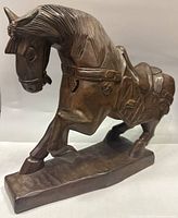 Front and side views of vintage hand carved wooden horse figurine sculpture showing detailed carving and prancing pose.