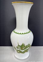 Full profile front of white porcelain vase with green and gold hand painted Asian style dragon and gold rim.