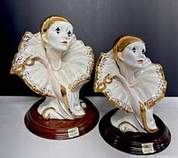 Front view of two Capodimonte Pierrot clown figurines on wood bases, showing facial details and ruffled collars