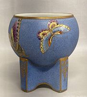 Front and side view of the antique Nippon vase showing the blue base color, multicolored hand painted butterflies and gold accents.