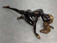 Bronze Art Deco nude woman sculpture viewed from front and side showing kneeling pose with extended leg and golden hair.