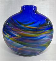 Photo of the front view of the rounded cobalt blue glass vase with multicolor swirls.