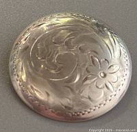 Front view of the vintage sterling silver brooch showing floral and scroll engraved design.