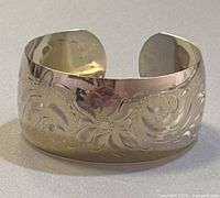 Front view showing engraved floral scroll design across cuff