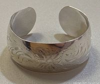 Front view of cuff showing engraved floral scroll pattern