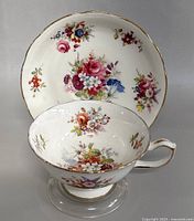 Teacup resting inside matching saucer, showing floral pattern and gold trim under good lighting