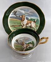 Teacup and saucer set with hunting dog and pheasant image, standing side and top views.