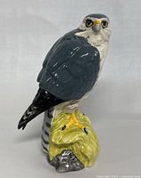 Front view of the ceramic falcon decanter showing detailed painted feathers, facial features, and base.